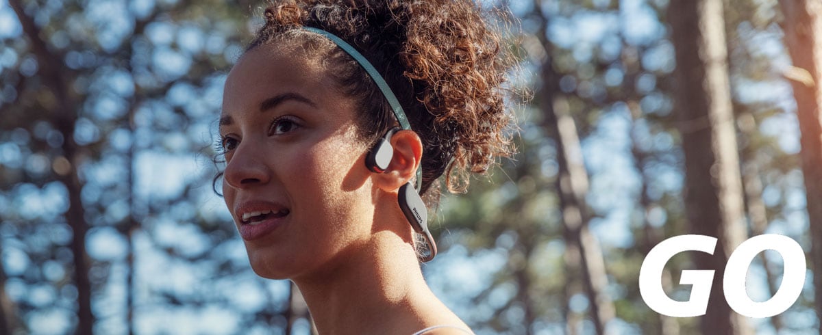 Krupni plan žene koja nosi sportske slušalice sa tehnologijom koštane provodljivosti