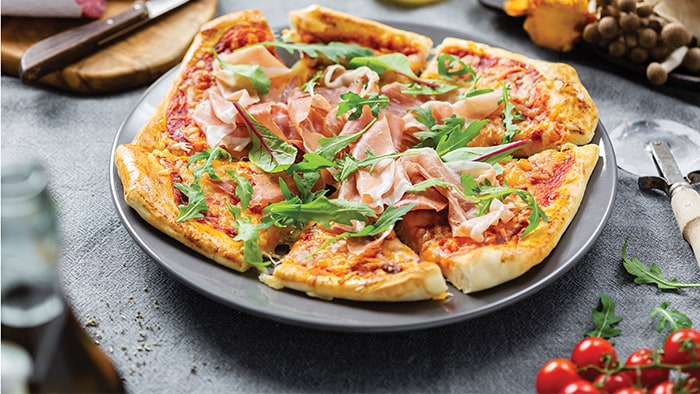 Pizza with ham and arugula
